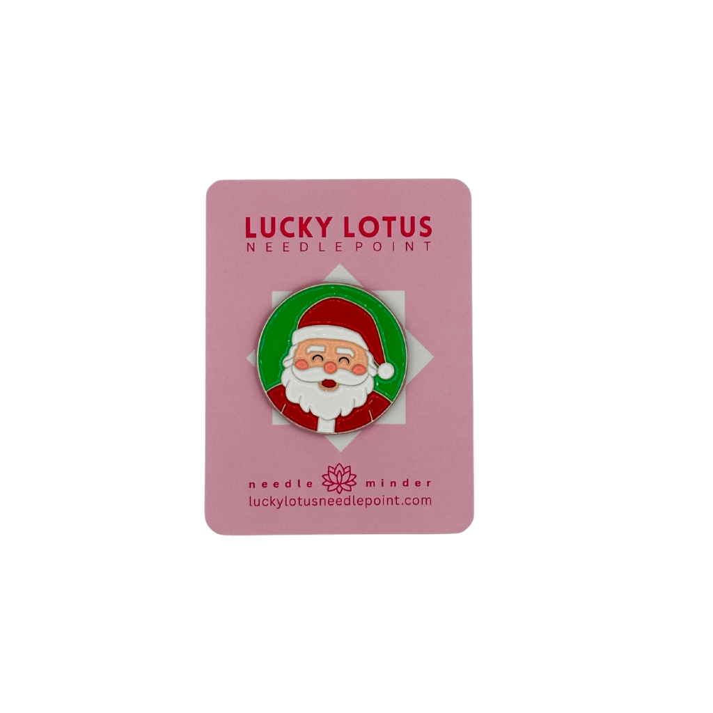 Santa Claus enamel needle minder on a Lucky Lotus Needlepoint card.